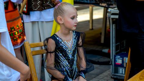 Mała artystka w kostiumie gimnastycznym czeka na swój występ