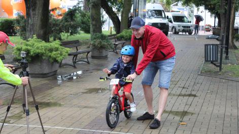 Tata trzyma rower chłopca i pomaga jemu wystartować